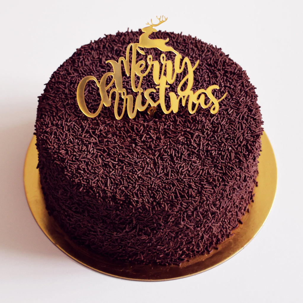 Chocolate cake with 'Merry Christmas' decoration on a white background